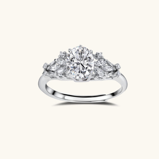Sterling silver ring with oval moissanite center stone surrounded by smaller accent stones in ornate setting