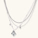 Multi-strand layered necklace set with silver chains, white pearls, star charm, heart pendant, and ornate decorative piece