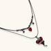 Dark layered necklace set with black chains and red heart pendants, featuring gothic snake design on white background
