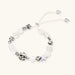 Adjustable beaded bracelet with spotted dalmatian stones, clear quartz crystals, and silver star charm on white background.