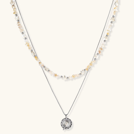 Two-layer necklace with natural stone chips and eco-brass beads, featuring a circular wrapped pendant on cream background.
