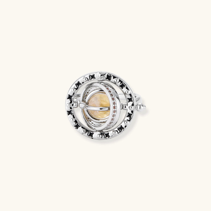 Adjustable brass ring with rotating zirconia center, surrounded by black enamel celestial stars and moon details