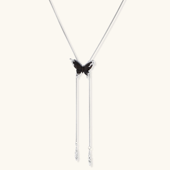 Wooden butterfly pendant necklace with cascading silver-toned chains on adjustable chain, available in amber and black.