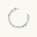 Delicate wire-wrapped bracelet featuring turquoise, rose quartz, freshwater pearls, and zircon on a white background.