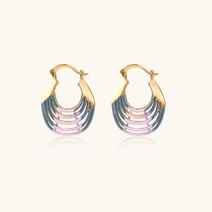 Gold hoop earrings with gradient blue-to-pink enamel in ribbed fan design on beige background