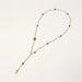 Y-shaped gold-plated necklace with white and gray freshwater pearls on cream background, showing adjustable drop design.