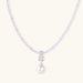 Dainty necklace with lavender crystal beads, freshwater pearls, geometric pendant, and large pearl drop on white background.