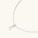 Dainty necklace with lavender crystal beads, freshwater pearls, geometric pendant, and large pearl drop on white background.