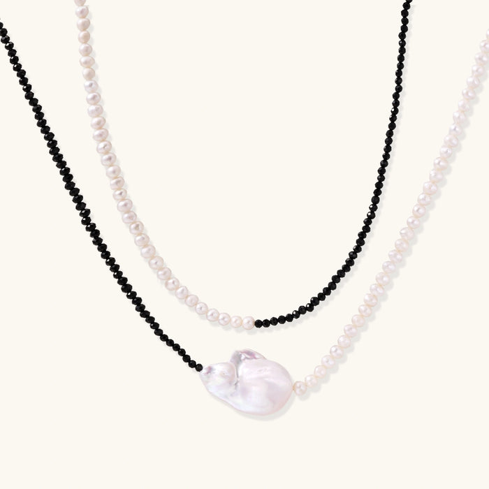 Double-strand necklace with black faceted quartz and white pearls featuring an oversized baroque pearl centerpiece