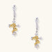 Ornate gold plated cross drop earrings with rose details and sparkling zirconia stones on white background.