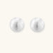 Brushed sterling silver half-dome clip-on earrings with textured surface against cream background