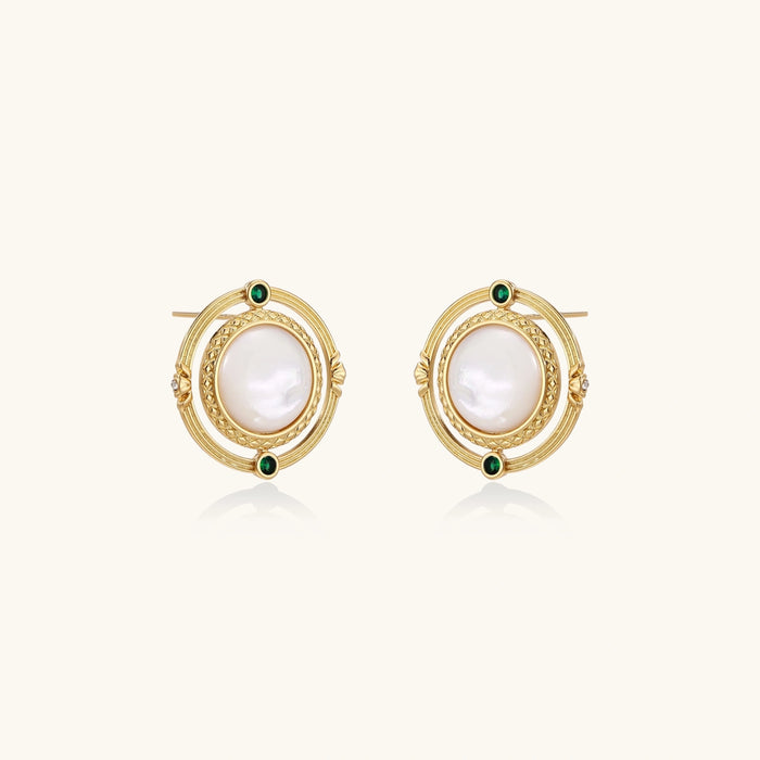 Circular gold stud earrings with iridescent mother-of-pearl center and green zirconia accents on cream background.