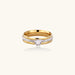 Gold-plated double-band ring with center rhinestone solitaire and channel-set stones on white background