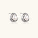Triangular white gold plated stud earrings with central freshwater pearl and baguette-cut stones on white background
