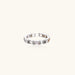 White gold plated ring with architectural lattice design and zirconia accents on cream background